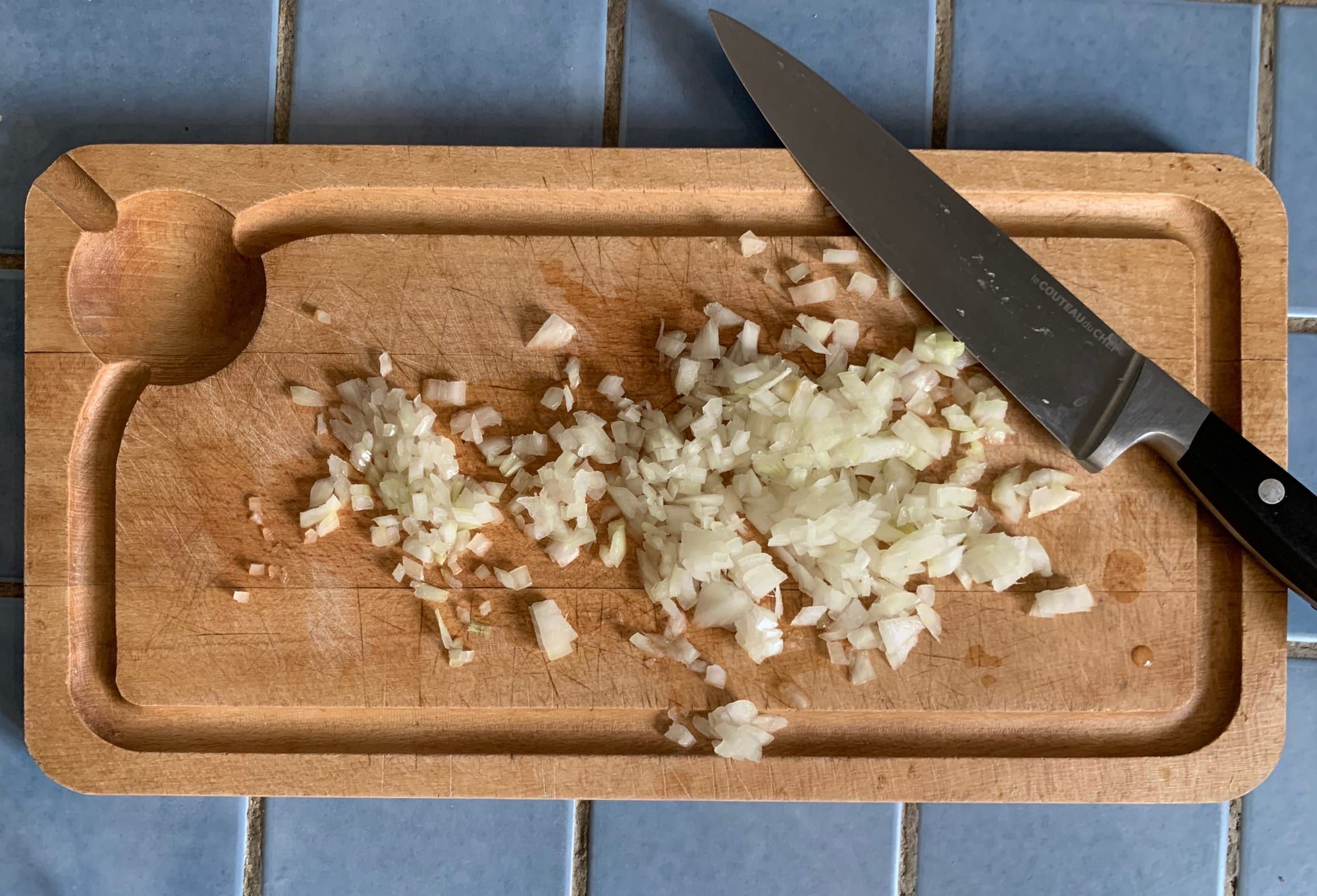 Finely chopped onion on a wooden cutting board